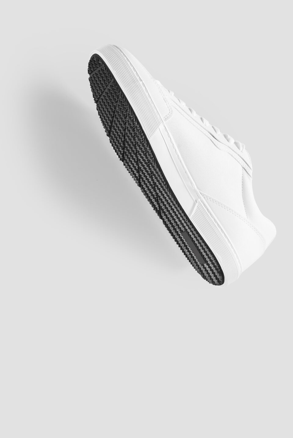 Mockup of basic white sneakers against a light grey background